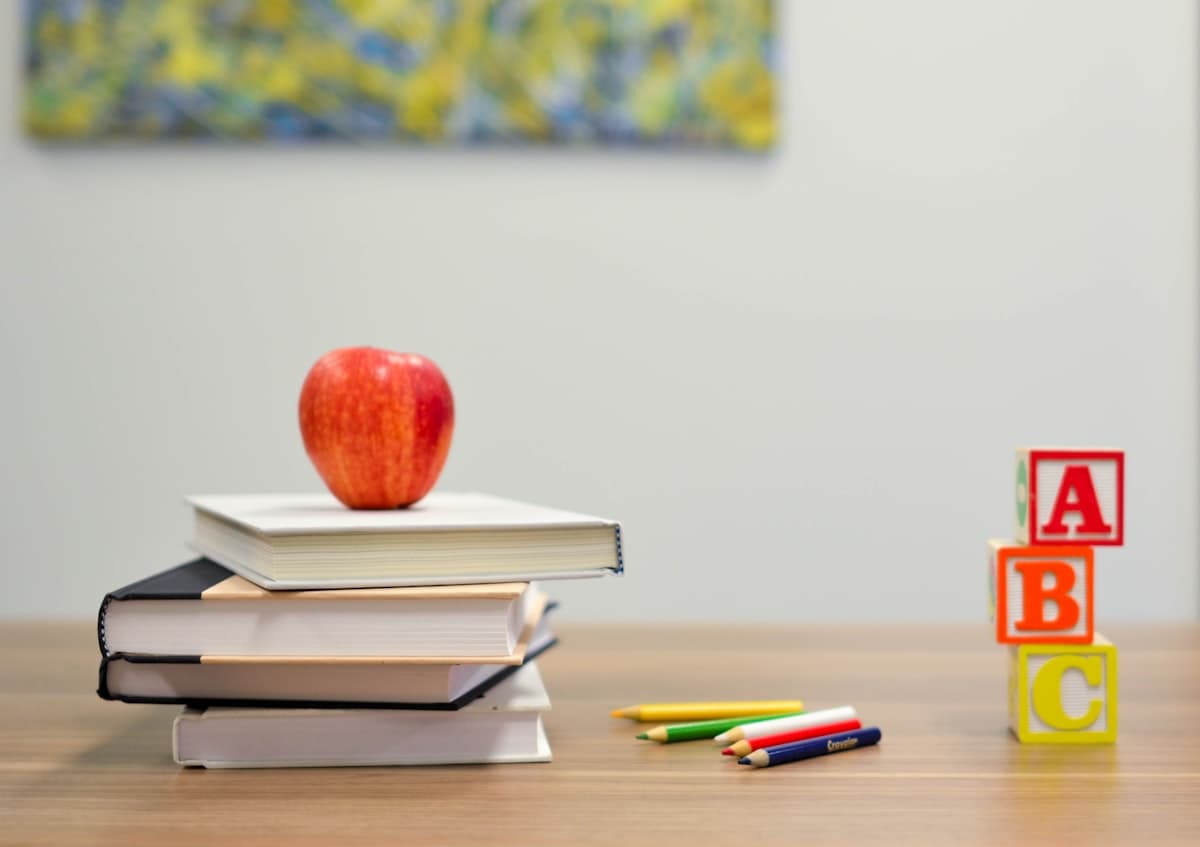 Stacked books with an apple and ABC blocks