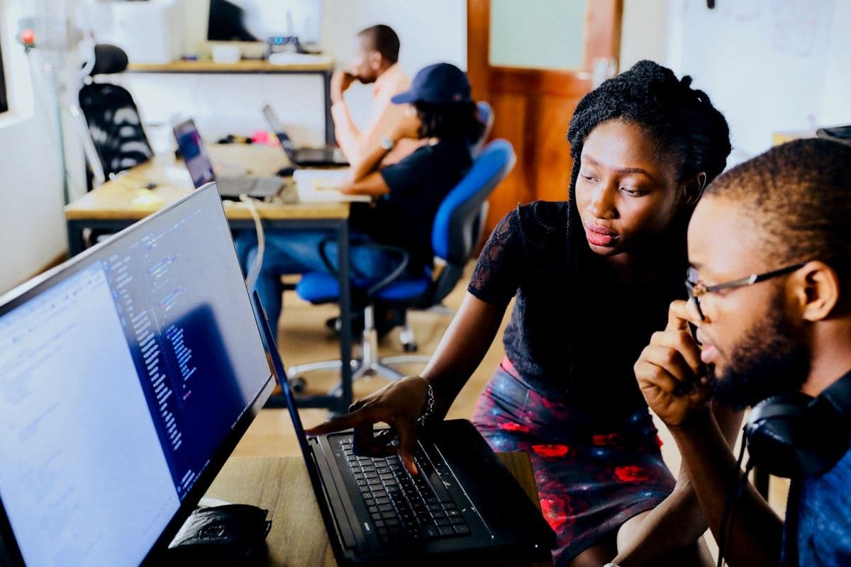 An educator coaching a learner through work on a laptop