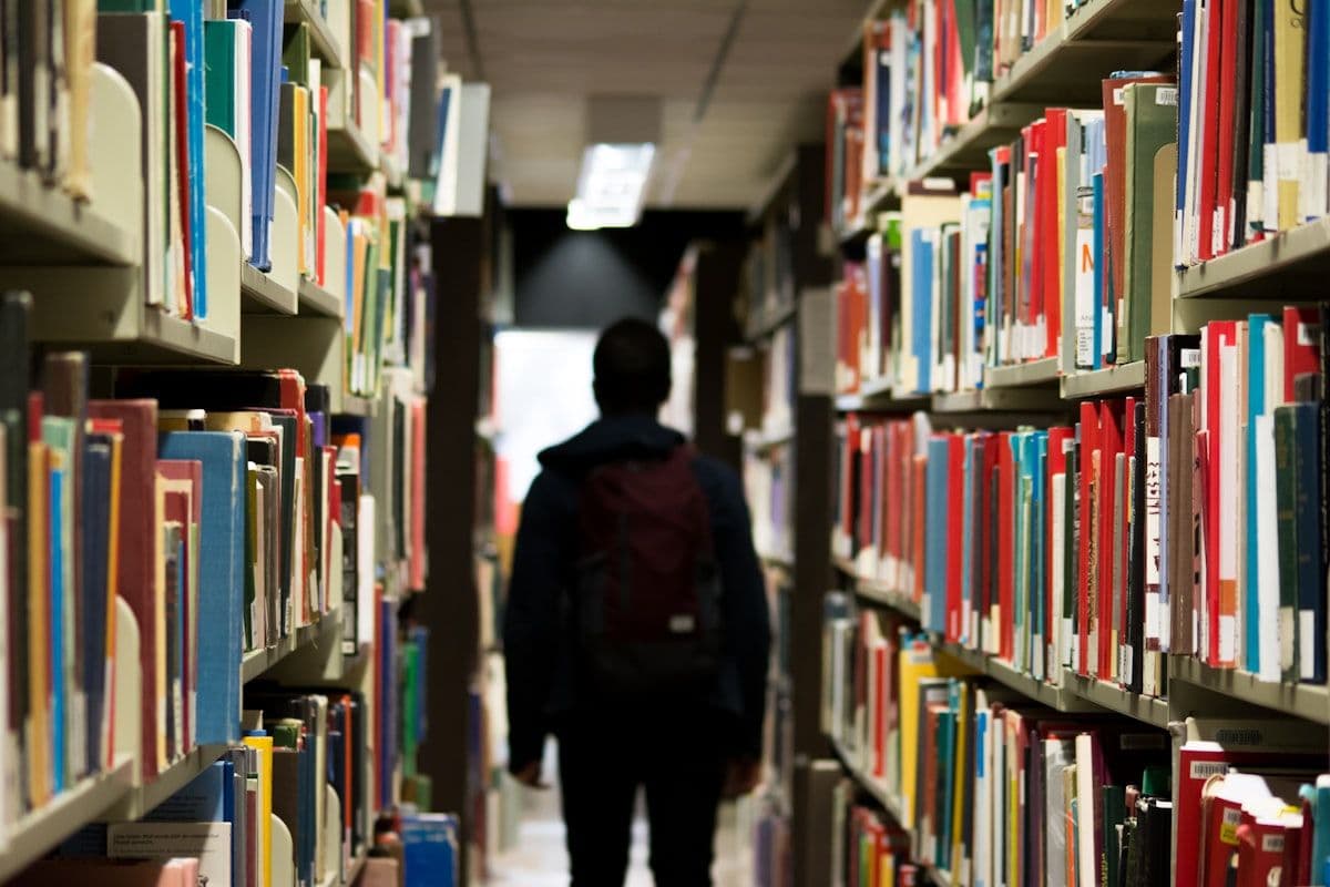 A researcher walking through library stacks